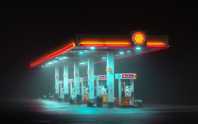 a gas station lit up at night on the water